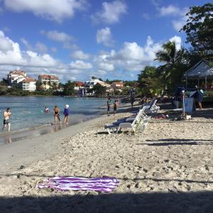 een groep mensen op een strand met water bij Location Les Arômes Anse Mitan Trois Ilets Martinique in Les Trois-Îlets