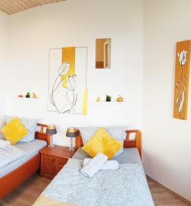 two beds in a room with yellow and blue pillows at ELENA flat Tulpe Duisburg Zentrum in Duisburg