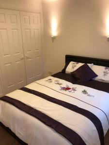 a bedroom with a bed with flowers on it at Oaklawn serviced apartments in Woking