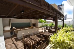 un patio avec des chaises et un bar dans un bâtiment dans l'établissement Astron Suítes Mondial Salvador by Nobile, à Salvador