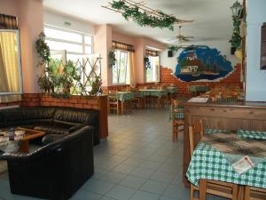 a restaurant with leather couches and tables and chairs at Angelica Apartments in Sidari