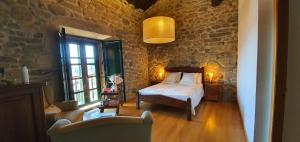 a bedroom with a bed and a stone wall at Casa Grande de Cristosende in Cristosende