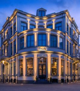 a large white building with lights on it at FINCH - boutique hotel in Deventer