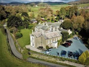 an aerial view of a large house with parked cars at Aynsome Manor Hotel in Cartmel