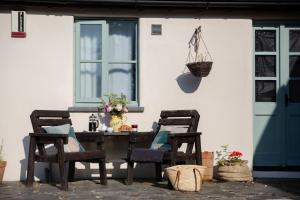 un tavolo da patio con due sedie e un cestino sul muro di Honeysuckle a Bude