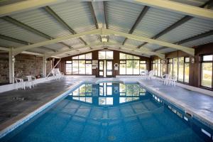 an indoor swimming pool with a large ceiling at Coach House in Bude