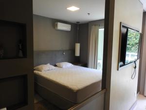 a small bedroom with a bed and a window at Brisas do Lago - Apartamento 8 in Brasília