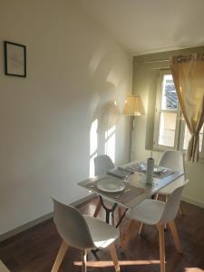 une salle à manger avec une table et des chaises blanches dans l'établissement Modern Duplex Apartment Centre Ville D'avignon, à Avignon