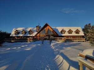 a house covered in snow with snow covered ground at Camp Taureau - Altaï Canada in Saint-Michel-des-Saints