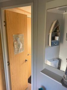 a bathroom with a door and a toilet and a mirror at Mountain View in Millom