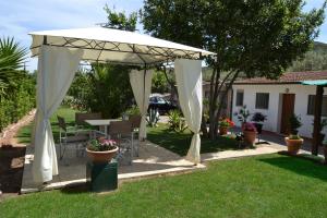 a white canopy in a yard with a table and chairs at da lina in Porto Santo Stefano