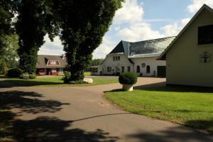 a house and a church with a tree and a driveway at Apartment Erdgeschoss in Hohenlockstedt