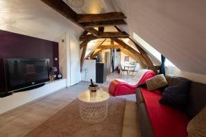 a living room with a red couch and a tv at Loveappart21 Pimentez votre vie de couple in Dijon