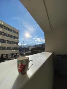 una taza de café sentada en una cornisa en un balcón en Alpha Apartment en Brasov