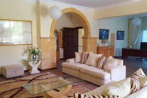 uma sala de estar com um sofá e uma mesa em Stunning Private Villa - Beautiful Gardens & Pool em Lapithos