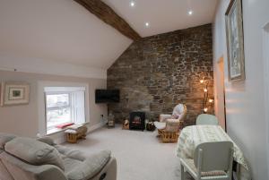 a living room with a couch and a stone wall at Charming 2-Bed Apartment in Donegal Town Centre in Donegal