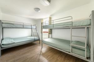 two bunk beds in a room with a wooden floor at Old School House -Yorkshire Dales National Park in Weathercote