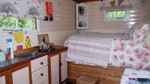 a small bedroom with a bed and a sink at Cosy Shepherds Hut nr Kynance cove in Lizard