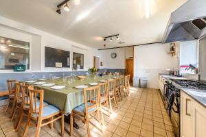 a long dining room with a table and chairs at Old School House -Yorkshire Dales National Park in Weathercote