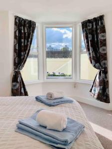 a bedroom with two towels on a bed with a window at Beachfront Retreat With Panoramic Views Of The Bay in Whitstable