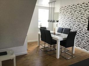 a dining room with a white table and black chairs at 4-Bed Cottage in Portknockie Near Cullen Moray in Portknockie +8 photos