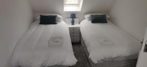 two beds sitting next to each other in a room at 4-Bed Cottage in Portknockie Near Cullen Moray in Portknockie