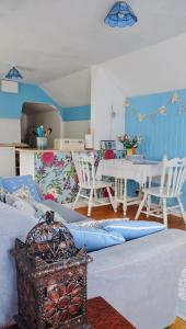 a living room with a couch and a table and chairs at Wellspring Cottage nr Kynance Cove in Lizard