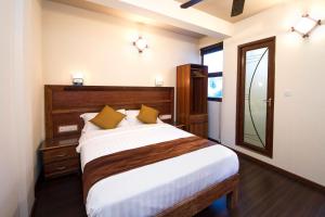ein Schlafzimmer mit einem großen Bett und einem Spiegel in der Unterkunft Tropic Tree Maldives in Gulhi