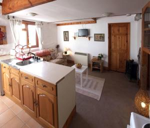 a kitchen with a sink and a living room at Inviting 2-Bed Cottage in Newcastle Emlyn in Newcastle Emlyn