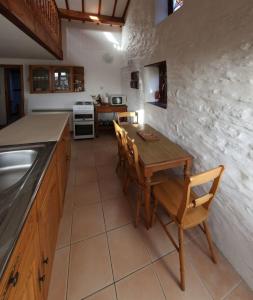 a kitchen with a wooden table and chairs in a kitchen at Inviting 2-Bed Cottage in Newcastle Emlyn in Newcastle Emlyn