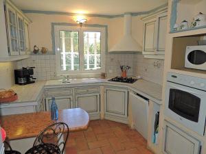 uma cozinha com armários brancos, uma mesa e um micro-ondas em La Mastineria - private pool em Emponse
