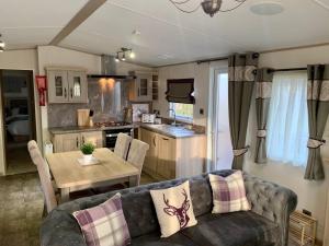a living room with a couch and a table and a kitchen at Sherwood Lodge - South Lakeland Leisure Village in Warton