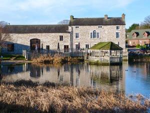 a large stone building with a dock in the water at Sherwood Lodge - South Lakeland Leisure Village in Warton