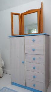 a dresser with a mirror on top of it at Cosy & Quirky Cottage nr Kynance cove in Lizard