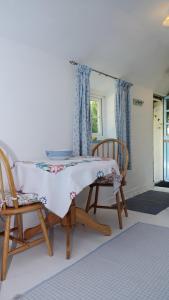 a bedroom with two chairs and a table with a blanket at Cosy & Quirky Cottage nr Kynance cove in Lizard