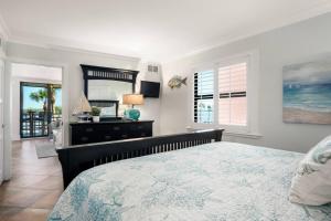 a bedroom with a bed and a dresser and a mirror at Riverside Club E201 in Marco Island