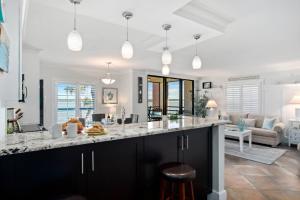 a kitchen with black and white countertops and a living room at Riverside Club E201 in Marco Island