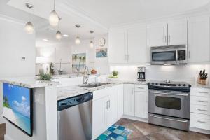 a kitchen with white cabinets and stainless steel appliances at Riverside Club E201 in Marco Island