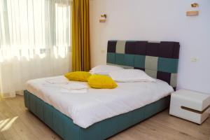 Un dormitorio con una cama con almohadas amarillas. en BLISS Dubova en Dubova