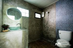 ein Bad mit einer Dusche, einem Waschbecken und einem WC in der Unterkunft Sichang Marina Resort in Ban Tha Thewawong
