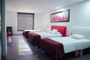 
a hotel room with two beds and a television at Hotel Merlott 70 in Medellín
