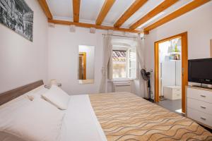 a bedroom with a large bed and a television at Apartments Espana 2 in Dubrovnik