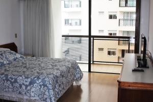 a hotel room with a bed and a large window at Apart Quadra Praia de Ipanema in Rio de Janeiro