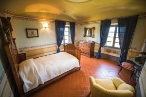 1 dormitorio con 1 cama y 1 silla en Villa Prato-Lami, en Casciana Terme