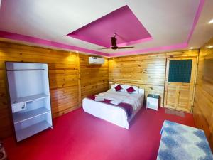 a bedroom with a bed and a purple ceiling at Om Sai Beach Huts in Agonda