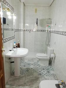 Baño blanco con lavabo y aseo en Rincón de la Fuenseca, en Córdoba