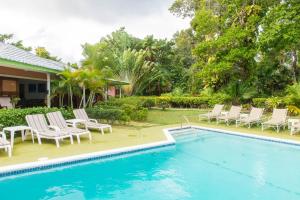 une piscine avec des chaises longues et une maison dans l'établissement Villa Viento, à St Mary