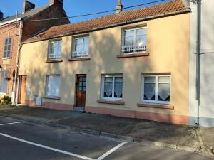 a yellow house with windows on a street at Les Flots de St Val in Saint-Valéry-sur-Somme