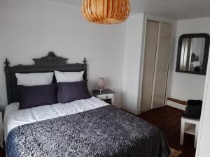 1 dormitorio con 1 cama grande y espejo en Les Flots de St Val, en Saint-Valery-sur-Somme
