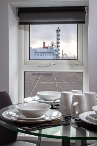 une table en verre avec des plaques blanches et une fenêtre dans l'établissement New Luxury Seaview Apt3 Free Parking Special Deal, à Blackpool